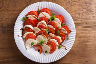 Dilimlenmiş domates, mozzarella peyniri, fesleğen, zeytinyağı ve balsamik sirke ile İtalyan caprese salatası. Yukarıda görmek, en iyi stüdyo vurdu 