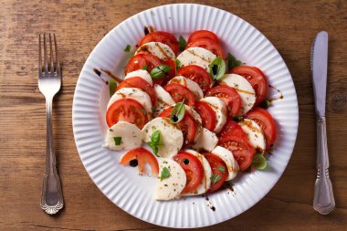 Dilimlenmiş domates, mozzarella peyniri, fesleğen, zeytinyağı ve balsamik sirke ile İtalyan caprese salatası. Yukarıda görmek, en iyi stüdyo vurdu 