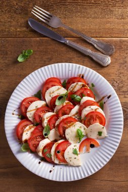 Dilimlenmiş domates, mozzarella peyniri, fesleğen, zeytinyağı ve balsamik sirke ile İtalyan caprese salatası. Yukarıda görmek, en iyi stüdyo vurdu 