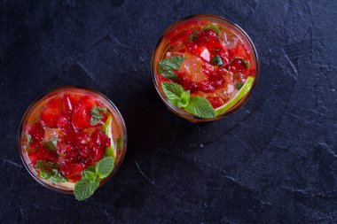 Çilek mojito çilek, limon, nane ve buz, siyah arka plan ile kokteyl. Yaz berry kokteyl. Yukarıda görmek, en iyi stüdyo vurdu