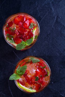 Çilek mojito çilek, limon, nane ve buz, siyah arka plan ile kokteyl. Yaz berry kokteyl. Yukarıda görmek, en iyi stüdyo vurdu