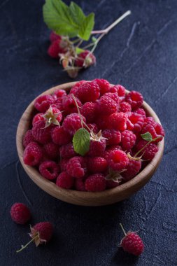 Ahududu siyah arka plan üzerine ahşap kase. Taze olgun tatlı çilek, sağlıklı gıda