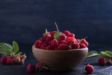 Ahududu siyah arka plan üzerine ahşap kase. Taze olgun tatlı çilek. Metin için yer