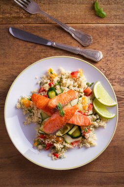 Domates kuskus, kabak ve kireç beyaz tabakta ile kavrulmuş somon balık. Tepegöz, dikey