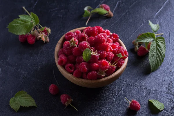 Ahududu siyah arka plan üzerine ahşap kase. Taze olgun tatlı çilek, sağlıklı gıda
