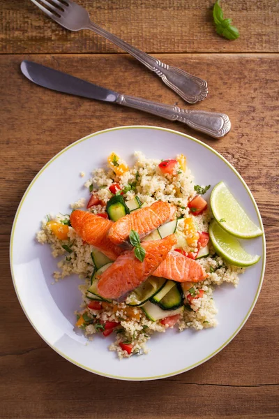 Domates kuskus, kabak ve kireç beyaz tabakta ile kavrulmuş somon balık. Tepegöz, dikey