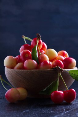 Siyah arka plan üzerine ahşap kase taze kiraz. Taze olgun tatlı kiraz