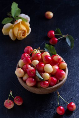 Siyah arka plan üzerine ahşap kase taze kiraz. Taze olgun tatlı kiraz