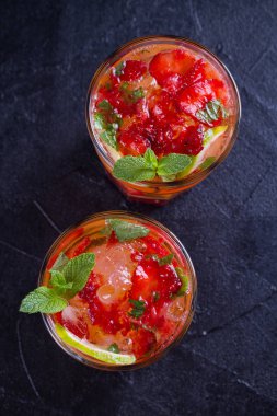 Çilek mojito çilek, limon ve nane ile kokteyl. Yaz meyve siyah arka plan üzerine kokteyl. Tepegöz, dikey