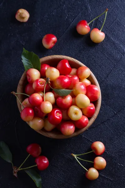 Siyah arka plan üzerine ahşap kase taze kiraz. Taze olgun tatlı kiraz. Yukarıda görmek, en iyi stüdyo vurdu