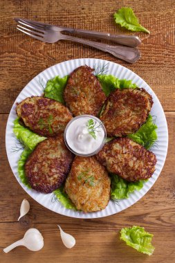 Ekşi krema ya da yoğurt ile patates gözlemesi. Sebze börek, latkeler, draniki. Yukarıda görmek, en iyi stüdyo vurdu