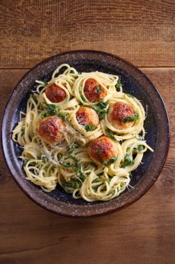 Köfte ve ıspanak ile makarna. Köfte ahşap masa üzerinde kase spagetti. Tepegöz, dikey 