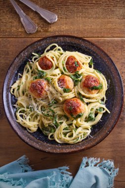 Köfte ve ıspanak ile makarna. Köfte ahşap masa üzerinde kase spagetti. Tepegöz, dikey 