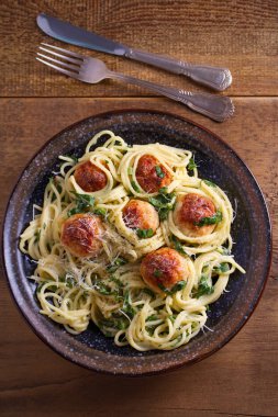 Köfte ve ıspanak ile makarna. Köfte ahşap masa üzerinde kase spagetti. Tepegöz, dikey 