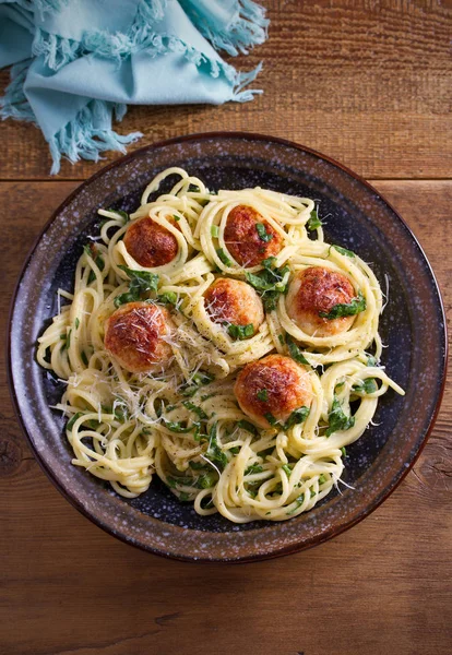 Köfte ve ıspanak ile makarna. Köfte ahşap masa üzerinde kase spagetti. Tepegöz, dikey 