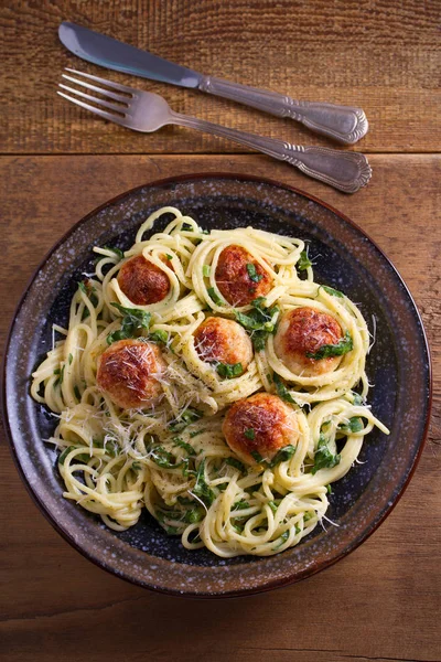Köfte ve ıspanak ile makarna. Köfte ahşap masa üzerinde kase spagetti. Tepegöz, dikey 
