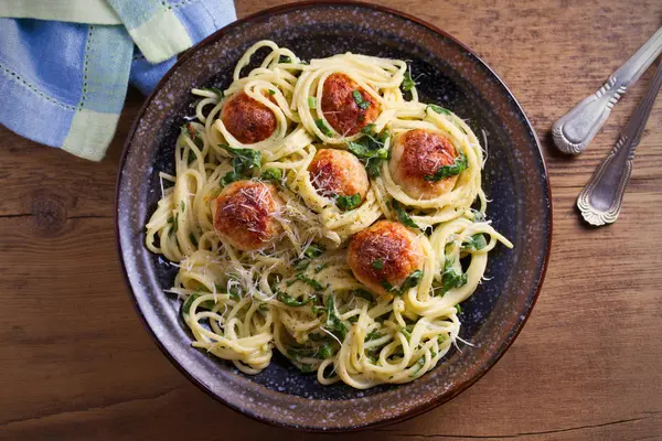 Köfte ve ıspanak ile makarna. Köfte ahşap masa üzerinde kase spagetti. Tepegöz, yatay 