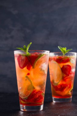 Çilek mojito çilek, limon ve nane ile kokteyl. Yaz meyve siyah arka plan üzerine kokteyl. metin, dikey için yer
