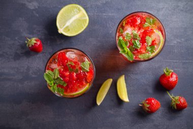 Çilek mojito çilek, limon ve nane ile kokteyl. Yaz meyve siyah arka plan üzerine kokteyl. Tepegöz, yatay