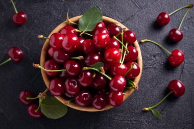 Siyah arka plan üzerine ahşap kase taze kiraz. Taze Olgun kırmızı tatlı kiraz. Tepegöz, yatay