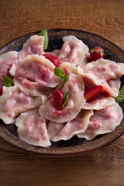 Çilek ile dolu köfte, çilek. Pierogi, varenyky, vareniki, pyrohy - köfte doldurma, birçok ülkede popüler çanak ile. dikey