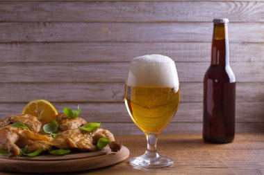 Cam ve şişe bira ve spatchcock tavuk. İyi pişmiş ve sulu tavuk gazoz için iyi bir besindir. Bira ve et. Metin için yer