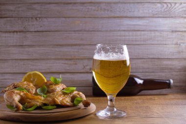 Cam ve şişe bira ve spatchcock tavuk. İyi pişmiş ve sulu tavuk gazoz için iyi bir besindir. Bira ve et. Metin için yer