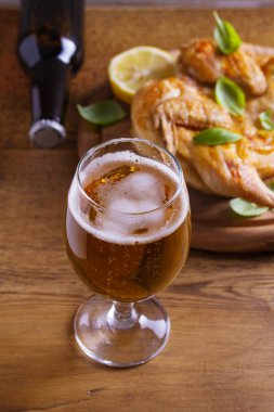 Cam ve şişe bira ve spatchcock tavuk. İyi pişmiş ve sulu tavuk gazoz için iyi bir besindir. Bira ve et