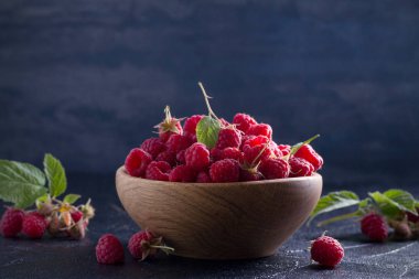 Ahududu siyah arka plan üzerine ahşap kase. Taze olgun tatlı çilek, sağlıklı yemek. Yaz meyveleri. Yatay