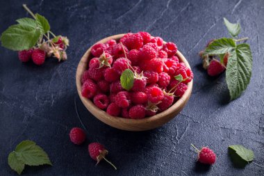 Ahududu siyah arka plan üzerine ahşap kase. Taze olgun tatlı çilek, sağlıklı yemek. Yaz meyveleri. Yatay