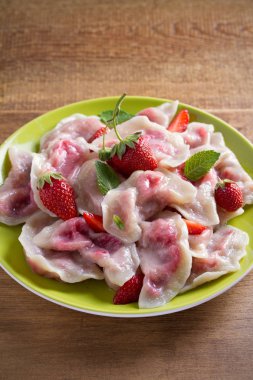 Çilek lezzetli köfte. Çilek ile mantı. Varenyky, vareniki, pierogi, pyrohy. dikey