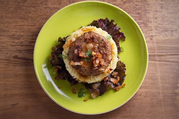 Lezzetli burger veya patty marul, patates püresi ile servis ile tuzlu karamelize soğan. Tepegöz, yatay