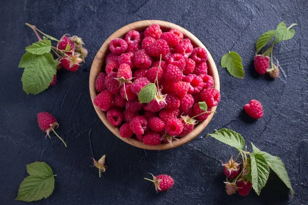 Ahududu siyah arka plan üzerine ahşap kase. Taze olgun tatlı çilek, sağlıklı yemek. Yaz meyveleri. Tepegöz, yatay