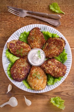 Patates börek, latkeler, draniki, kıymalı patates - birçok ülkede popüler çanak. Beyaz plaka, ahşap masa üzerinde sebze krep. Tepegöz, dikey