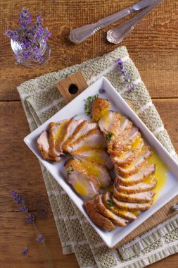 Beyaz tabakta Portakal soslu ördek göğsü. Ördek bonfile göğüs. Tepegöz, dikey