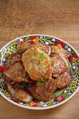 Patates kızartması, latkeler, draniki, kızarmış patates. Ahşap masa bir tabakta sebze krep. dikey