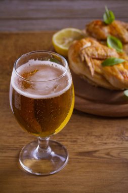 Bardak bira ve kızarmış tavuk. İyi pişmiş ve sulu tavuk gazoz için iyi bir besindir. Bira ve et. dikey