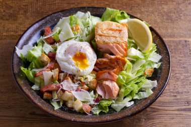 Somon Sezar salatası. Gevrek pan kızarmış somon fileto, pastırma, haşlanmış yumurta, marul ve kruton parmesan peyniri ile giyinmiş