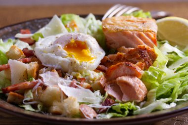 Somon Sezar salatası. Gevrek pan kızarmış somon fileto, pastırma, haşlanmış yumurta, marul ve kruton parmesan peyniri ile giyinmiş