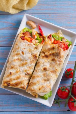 Tavuklu Sezar salata pastırma, domates, marul ve peynir ile tamamladı. Tortilla, burrito, bükülmüş sandviç rulo. Yukarıdan görüntülemek, top
