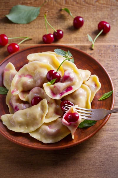 Kiraz ile mantı. Pierogi, varenyky, vareniki, pyrohy - köfte berry dolgu ile. dikey