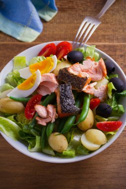 Salata salata somon. Domates, yeşil fasulye, yeni patates, zeytin ve marul salatası somon. dikey