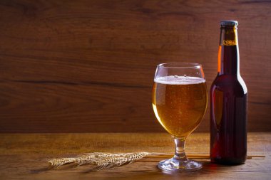 Cam ve şişe bira, kulakları arpa ahşap arka plan üzerinde. Ale. kopya alanı ile yatay