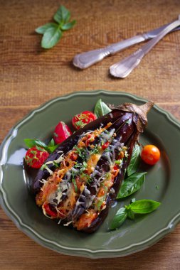 Fırında patlıcan, et, domates, kırmızı biber, soğan ve peynir ile doldurulmuş. Et ve sebze ile patlıcan