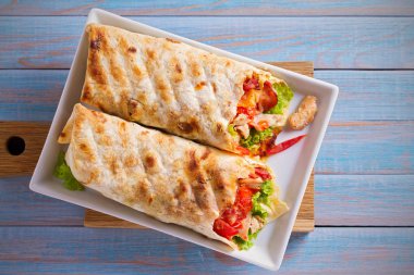 Tavuk pastırma, domates, marul ve peynir ile tamamladı. Tortilla, burrito, bükülmüş sandviç rulo. Tepegöz, yatay