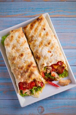 Tavuk pastırma, domates, marul ve peynir ile tamamladı. Tortilla, burrito, bükülmüş sandviç rulo. Tepegöz, dikey