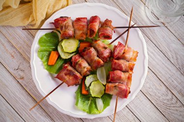 Tavuk ciğer şiş üzerinde pastırma ile sarılmış. Beyaz tabakta sebze ile karaciğer Kebap ızgara. Tepegöz, yatay
