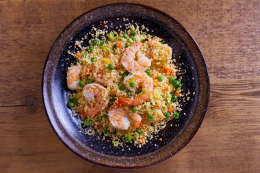 Karides kuskus, yeşil bezelye, pırasa ve havuç ile. Yukarıda görmek, en iyi stüdyo vurdu 