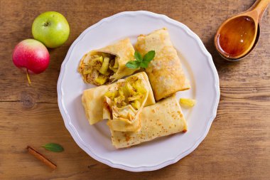 Tarçınlı elma krep. Krep karamelize elma ve tarçın, tahta kaşık tatlım. Yukarıda görmek, en iyi stüdyo vurdu  