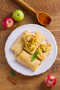 Tarçınlı elma krep. Krep karamelize elma ve tarçın, tahta kaşık tatlım. Yukarıda görmek, en iyi stüdyo vurdu  